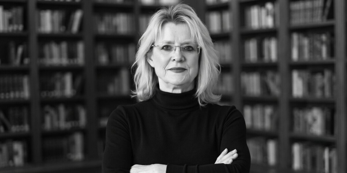 Sandra K. Griffith in front of bookshelves with arms crossed.