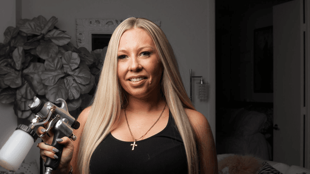 Nicole Hyatt holding spray tan equipment, founder of Tan on the Run mobile spray tan beauty franchise.