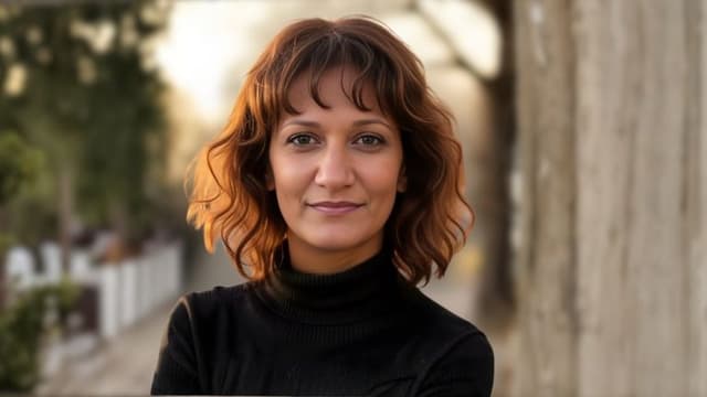 Dr. Jasmin Tzortzakakis Malik, a health educator with a focus on preventive care and empowerment, standing outdoors.