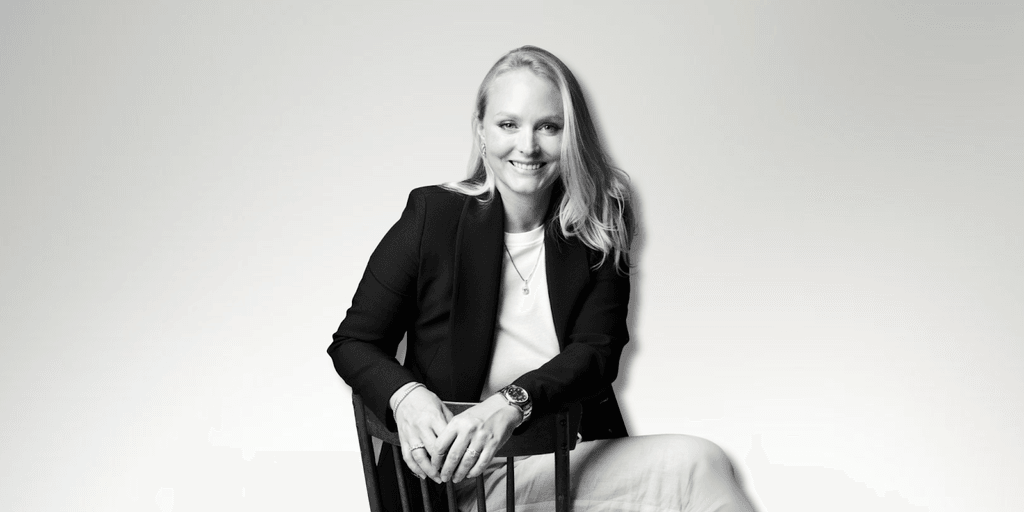 Milena Dold, founder of IRALIS, confidently seated and smiling, embodies the empowerment and luxury of self-purchased diamonds, symbolizing independence, achievement, and a redefined approach to personal milestones in the jewelry industry.